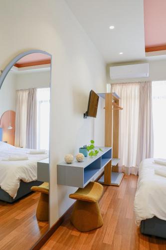 a bedroom with a mirror and a table and two beds at Ciao Xanthi Central Square Studio in Xanthi
