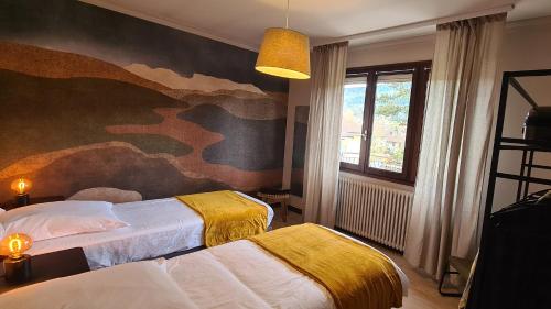 a bedroom with two beds and a painting on the wall at Appartement dans maison au calme in Oyonnax
