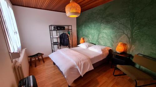 a bedroom with a bed with a green wall at Appartement dans maison au calme in Oyonnax