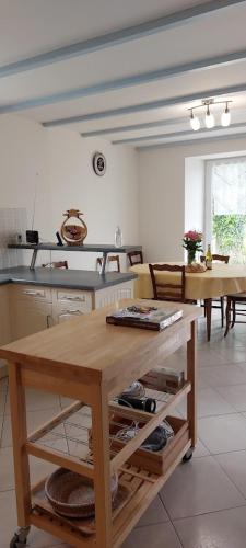 une cuisine avec une table et quelques tables et chaises dans l'établissement Eugénie, à Saint-Quentin-de-Chalais