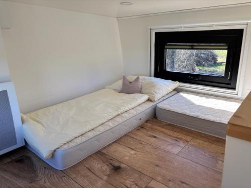 Postel nebo postele na pokoji v ubytování Tiny House mit Saunafass