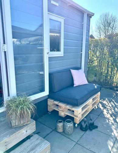 a bench on the front porch of a house at Zeeuws Ibiza huisje in Kamperland