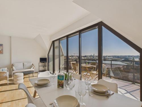 une salle à manger avec une table et des chaises et une grande fenêtre dans l'établissement Appartement vue mer à 350m de la plage pour 4, à Saint-Gilles-Croix-de-Vie
