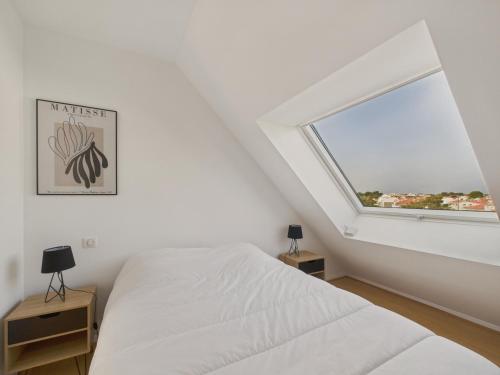 une chambre avec un lit blanc et une fenêtre dans l'établissement Appartement vue mer à 350m de la plage pour 4, à Saint-Gilles-Croix-de-Vie