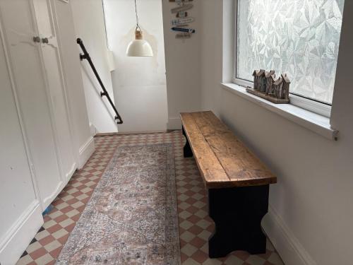 a hallway with a wooden bench next to a window at Delmonte Lodge in Torquay