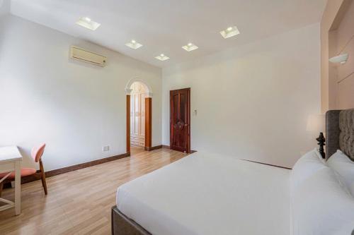 a bedroom with a bed and a table and a desk at Villa La Rose Blanc Thảo Điền in Ho Chi Minh City