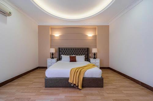 a bedroom with a bed and two night stands at Villa La Rose Blanc Thảo Điền in Ho Chi Minh City