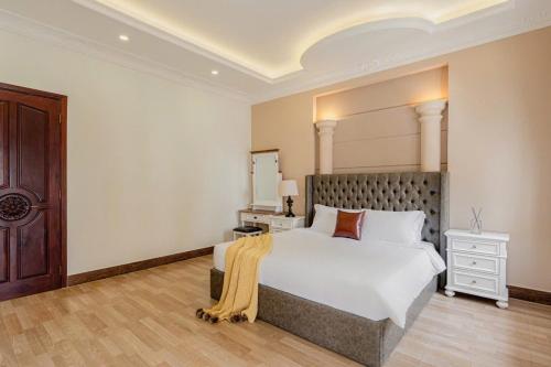 a bedroom with a large white bed and a wooden floor at Villa La Rose Blanc Thảo Điền in Ho Chi Minh City