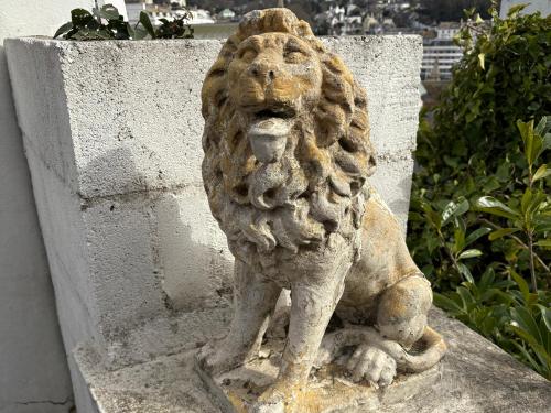 a statue of a lion sitting on a wall at Delmonte Lodge in Torquay
