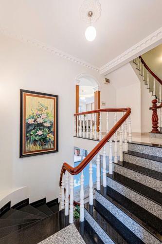a staircase in a home with a painting on the wall at Villa La Rose Blanc Thảo Điền in Ho Chi Minh City