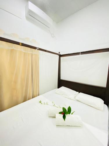 un lit avec deux serviettes et une plante dessus dans l'établissement Surferce dream guest house, à Ahangama