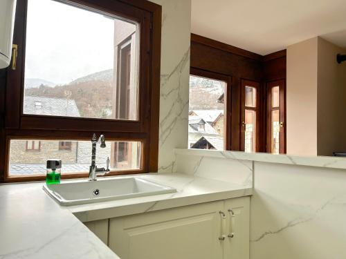 a kitchen with a sink and a window at Dúplex amb encant al centre d'Espot by RURAL D'ÀNEU in Espot
