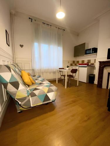 un salon avec un lit et une table dans l'établissement Petit descamps, à Rouen