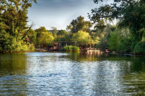 a large lake with trees on the side of it at Wineport Lodge Agva Riverside Hotel & Winery in Ağva