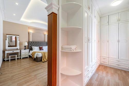 a bedroom with a bed and a dressing room at Villa La Rose Blanc Thảo Điền in Ho Chi Minh City