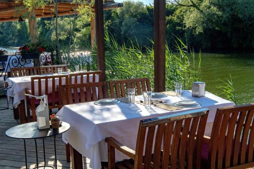 einen Tisch mit weißen Tischdecken auf einer Terrasse in der Unterkunft Wineport Lodge Agva Riverside Hotel & Winery in Agva