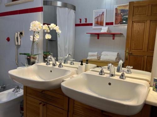 a bathroom with two white sinks and a tub at Large family appartament with pool in Sorrento