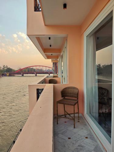 a house on the water with a chair on a dock at Gauri Gangaa in Haridwār