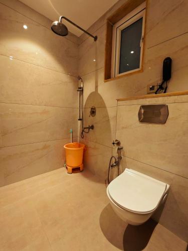a small bathroom with a toilet and a shower at Gauri Gangaa in Haridwār
