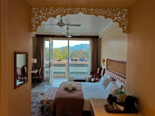 a bedroom with a large bed and a balcony at Gauri Gangaa in Haridwār