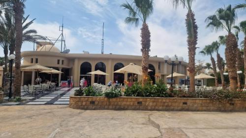 a resort with palm trees and a building at Hurghada Mirage Bay Resort & Aquapark in Hurghada