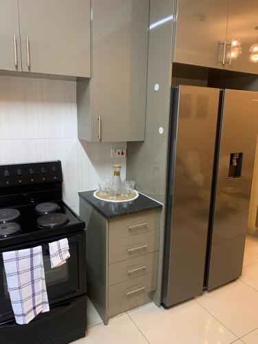 a kitchen with a stove and a stainless steel refrigerator at Comfort at home in Gaborone