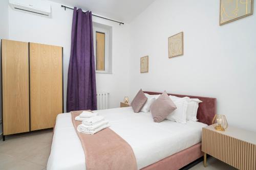 a bedroom with a large white bed with purple curtains at San Pietro Apartment 66 in Rome