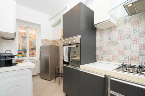 a kitchen with gray cabinets and a stove top oven at San Pietro Apartment 66 in Rome