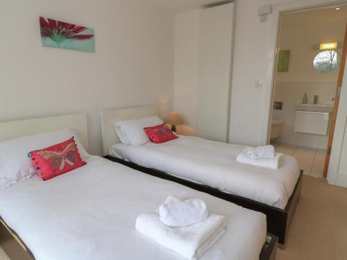 two beds in a room with red and white towels at The Skydeck HM50 in Cirencester