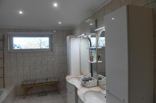 La salle de bains est pourvue d'un lavabo, d'une baignoire et d'une fenêtre. dans l'établissement Maison La Digue, à Plobsheim