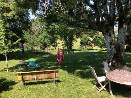 a park with a bench and a table and chairs at La Mariotte in Montredon