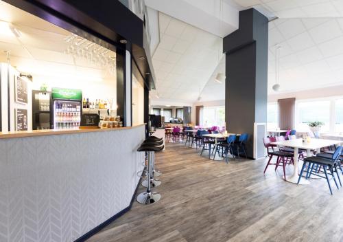 a restaurant with tables and chairs and a bar at Good Morning Västerås in Västerås
