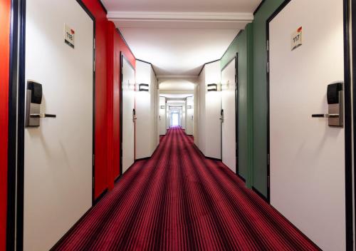 an empty corridor with red carpet in a hallway at Good Morning Västerås in Västerås