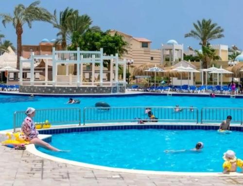 a group of people in a swimming pool at a resort at Hurghada Mirage Bay Resort & Aquapark in Hurghada
