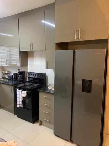 a kitchen with a stove and a refrigerator at Comfort at home in Gaborone