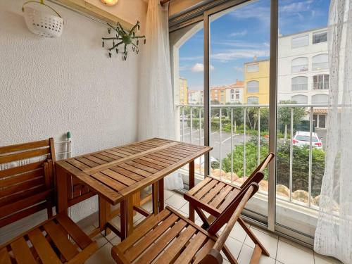 une table et deux chaises dans une pièce avec une fenêtre dans l'établissement Bel appartement T2 avec parking au Cap d'Agde - FR-1-749-86, au Cap d'Agde