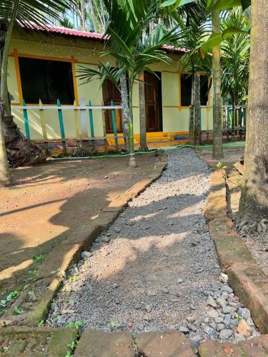 a house with palm trees in front of a street at Thakur holiday homes in Alibag