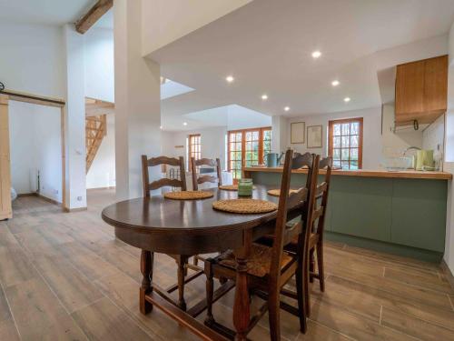 une cuisine et une salle à manger avec une table et des chaises dans l'établissement Pontenx-les-Forges : Maison 8p avec Jardin et Climatisation - FR-1-50-164, à Pontenx-les-Forges