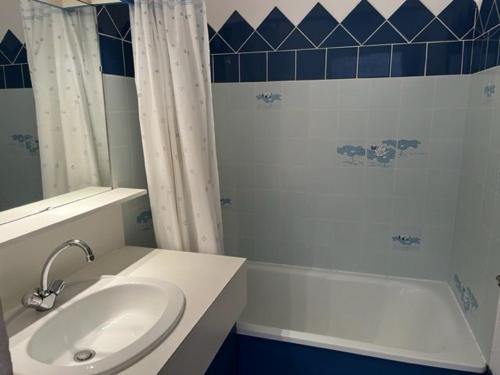 une salle de bain blanche avec un lavabo et une baignoire dans l'établissement Appartement RDC 2 chambres, terrasse, à 200m plage, parking, animaux admis - FR-1-749-89, au Cap d'Agde