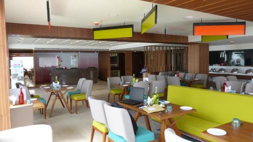 a dining room with tables and chairs and aktop at ZIBE Coimbatore by GRT Hotels in Coimbatore