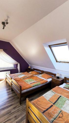 a bedroom with three beds and a window at Jaś i Małgosia nad Jeziorem Wigry in Rosochaty Róg