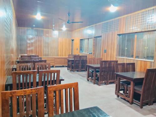 an empty room with wooden tables and chairs at New Sahil in Srinagar