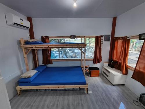 a bedroom with a bunk bed with a blue mattress at Red's Cafè & Resto- Glass Cabin in Manolo Fortich
