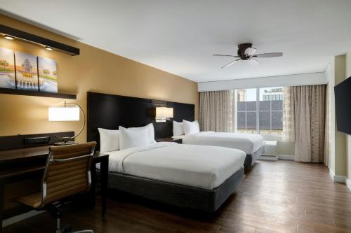 a hotel room with two beds and a desk at Courtyard by Marriott Charleston Historic District in Charleston