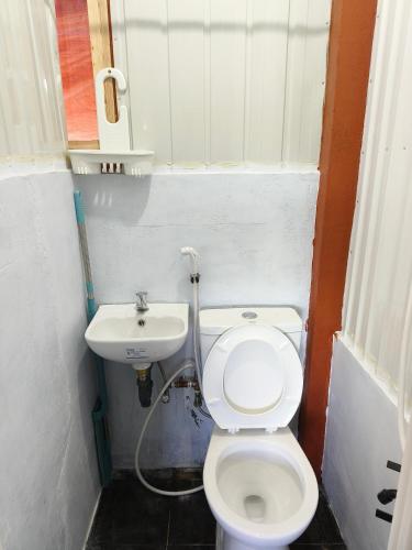 a small bathroom with a toilet and a sink at Red's Cafè & Resto- Glass Cabin in Manolo Fortich