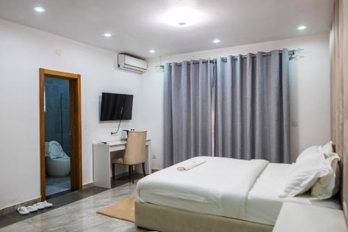 a bedroom with a bed and a desk and a television at Aylane Aparth Hotel in Nampula