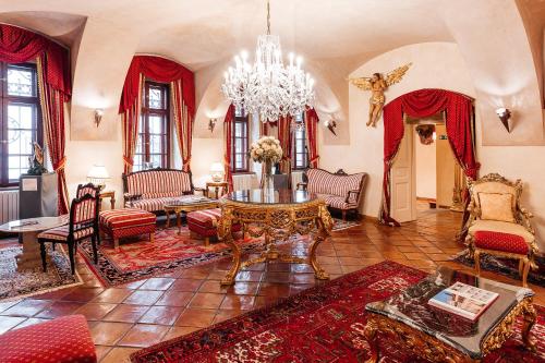 a living room with a table and chairs and a chandelier at Alchymist Grand Hotel and Spa - Preferred Hotels & Resorts in Prague