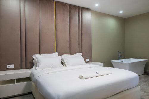 a bedroom with a large white bed and a sink at Aylane Aparth Hotel in Nampula