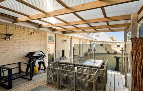 an outdoor patio with a wooden pergola at 5 Bedroom Nice Home In Blokhus in Blokhus