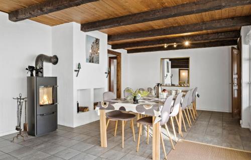 a dining room with a table and chairs and a fireplace at 5 Bedroom Nice Home In Blokhus in Blokhus